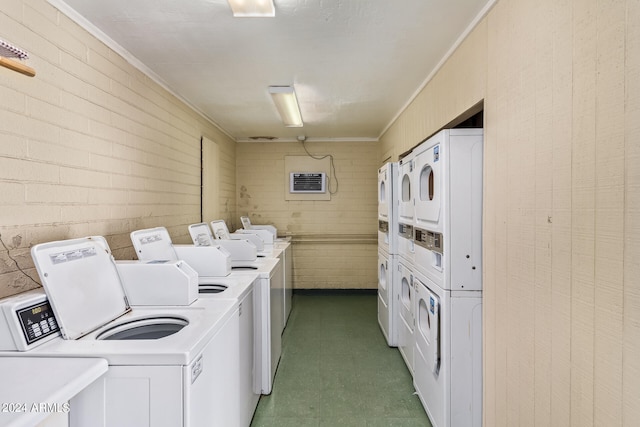 laundry room featuring stacked washing maching and dryer, brick wall, separate washer and dryer, and crown molding