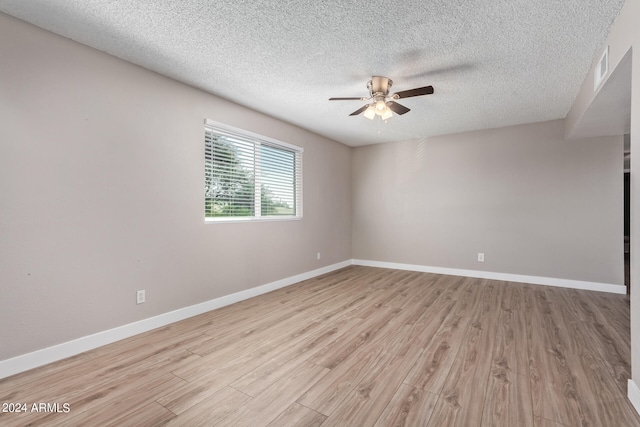 spare room with ceiling fan, a textured ceiling, and light wood-type flooring