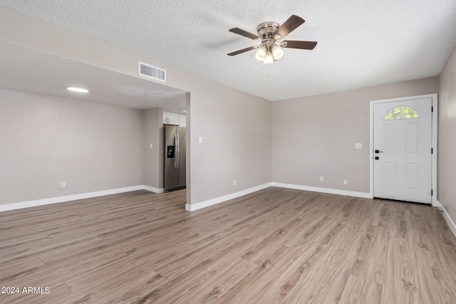 interior space featuring light hardwood / wood-style floors, ceiling fan, and a textured ceiling