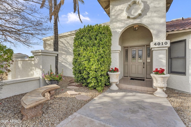 doorway to property with a tiled roof and stucco siding