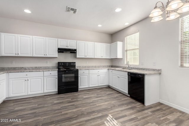 kitchen with visible vents, under cabinet range hood, wood finished floors, black appliances, and a sink