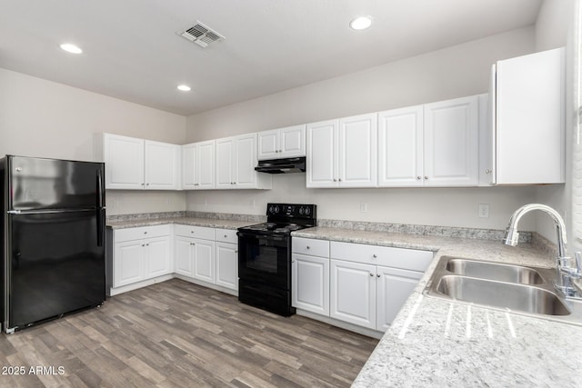 kitchen with visible vents, light wood-style flooring, a sink, black appliances, and under cabinet range hood