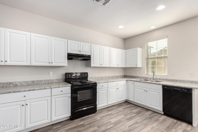 kitchen featuring visible vents, light wood-style flooring, a sink, black appliances, and under cabinet range hood