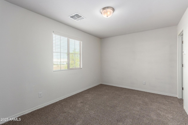 carpeted empty room featuring visible vents and baseboards