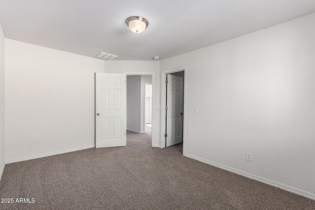 carpeted spare room featuring visible vents and baseboards