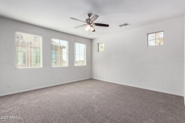 carpeted spare room with a ceiling fan, baseboards, and visible vents