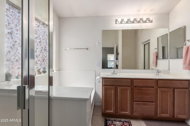full bath with double vanity, tile patterned floors, and a sink