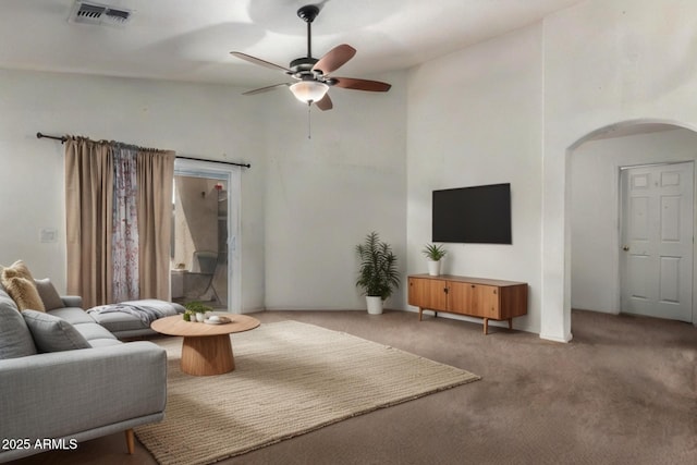 living room with carpet floors, arched walkways, high vaulted ceiling, a ceiling fan, and visible vents