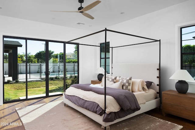 bedroom with wood-type flooring, access to outside, and ceiling fan