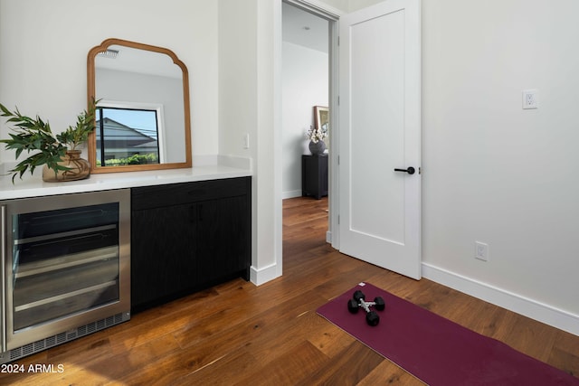 bar featuring dark hardwood / wood-style floors and beverage cooler