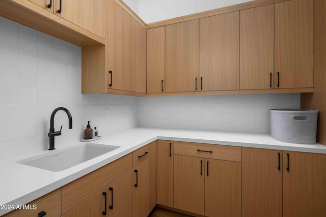 kitchen with backsplash, sink, and light brown cabinets