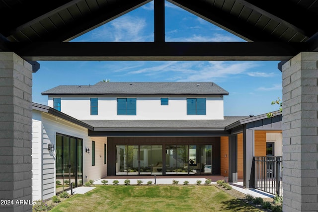 rear view of house featuring a lawn