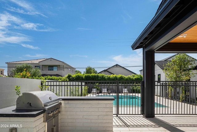 view of patio / terrace featuring a fenced in pool, area for grilling, and a grill