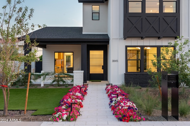 view of exterior entry with a lawn