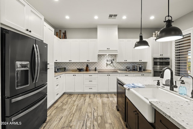 kitchen with sink, white cabinets, hanging light fixtures, black appliances, and light stone countertops