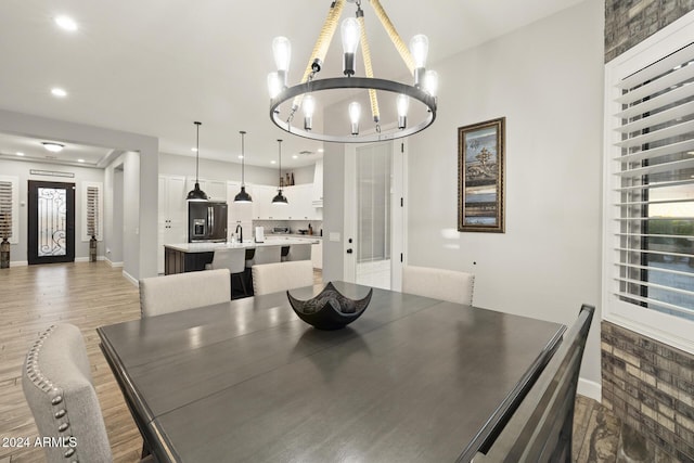 dining space featuring wood-type flooring and a chandelier