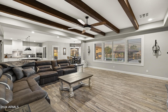 living room with ceiling fan, beam ceiling, and light hardwood / wood-style flooring