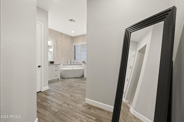 bathroom featuring vanity, hardwood / wood-style floors, and a tub