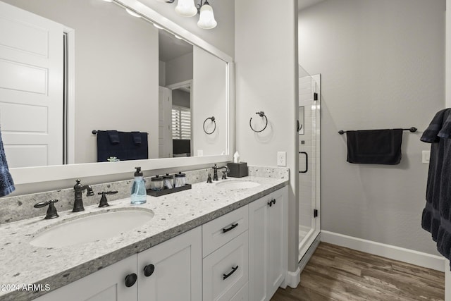 bathroom featuring an enclosed shower, vanity, and wood-type flooring