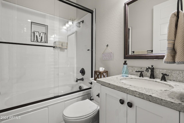 full bathroom with vanity, enclosed tub / shower combo, and toilet