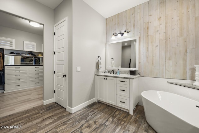 bathroom with vanity, hardwood / wood-style flooring, and a tub