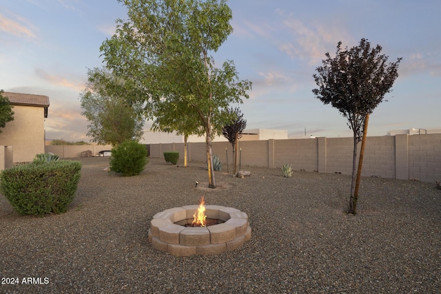 yard at dusk featuring a fire pit