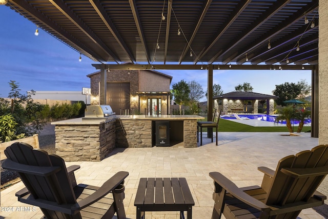 patio terrace at dusk with a grill and area for grilling