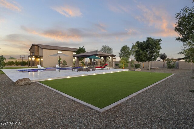 yard at dusk featuring a gazebo and a patio