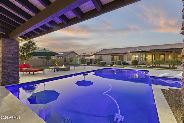 pool at dusk featuring a patio