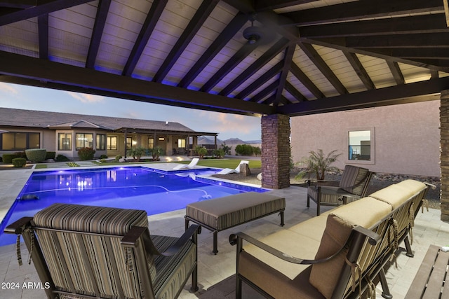 pool at dusk featuring a gazebo and a patio area