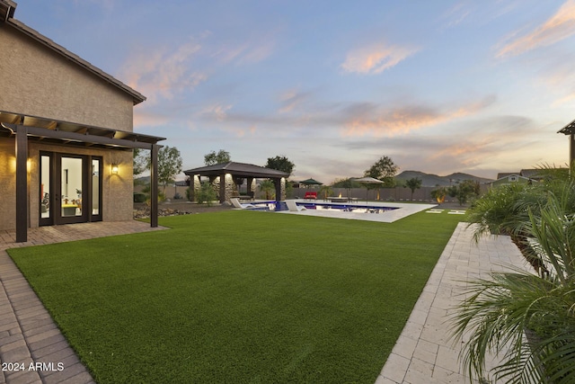 yard at dusk with a gazebo and a patio