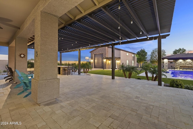 patio terrace at dusk with a pergola and a bar