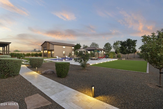 yard at dusk featuring a patio area