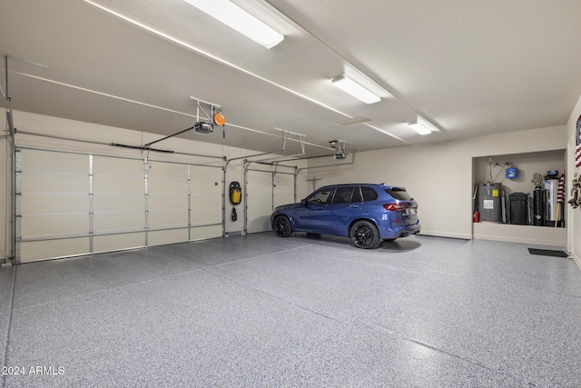 garage with a garage door opener and electric water heater