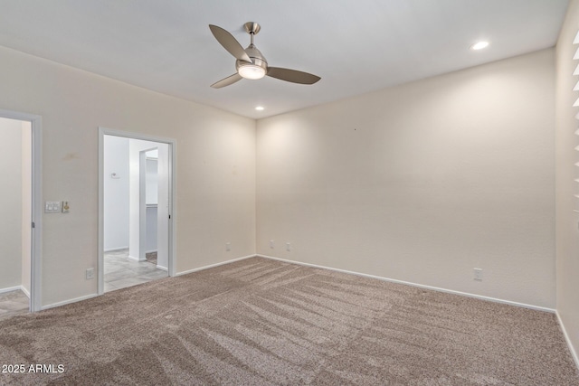 carpeted spare room featuring ceiling fan