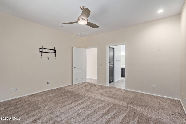 spare room featuring light carpet and ceiling fan