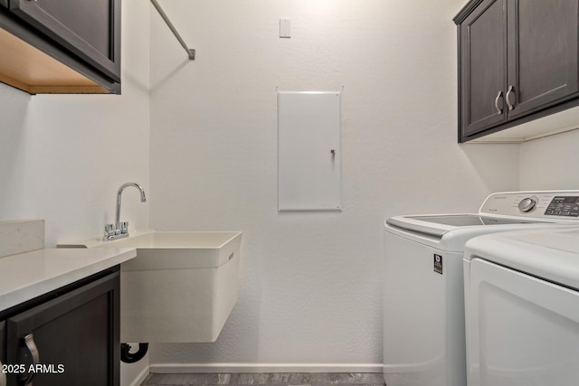 washroom with cabinets, sink, and washing machine and clothes dryer