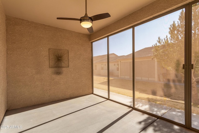 unfurnished sunroom with ceiling fan