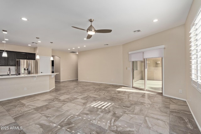 unfurnished living room featuring ceiling fan