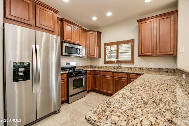 kitchen with sink, light stone countertops, stainless steel appliances, and light tile patterned floors