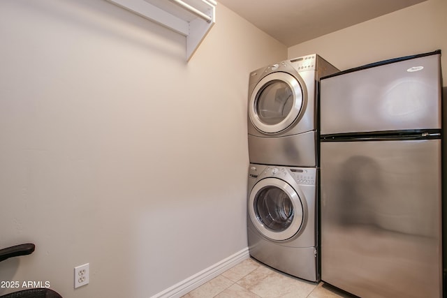 washroom with stacked washer / drying machine and light tile patterned flooring