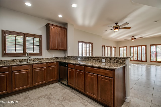 kitchen with kitchen peninsula, stainless steel dishwasher, a wealth of natural light, and sink