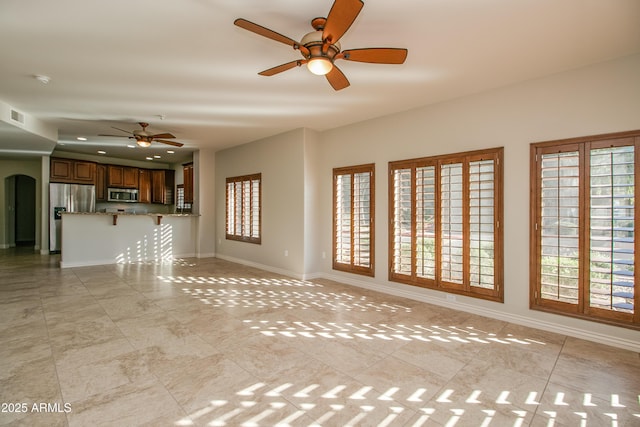 unfurnished living room featuring light tile patterned floors and ceiling fan