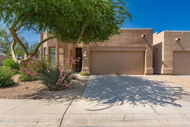 8324 E Cactus Wren Rd, Scottsdale, AZ 85250 - pueblo revival-style home with a garage, stucco siding, and driveway