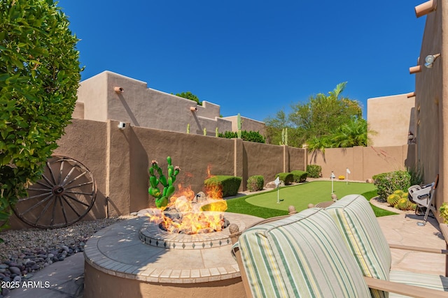 8324 E Cactus Wren Rd, Scottsdale, AZ 85250 - fenced backyard featuring a putting area, a fire pit, and a patio area