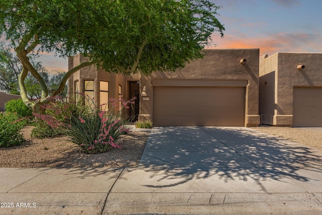 8324 E Cactus Wren Rd, Scottsdale, AZ 85250 - adobe home featuring an attached garage, concrete driveway, and stucco siding