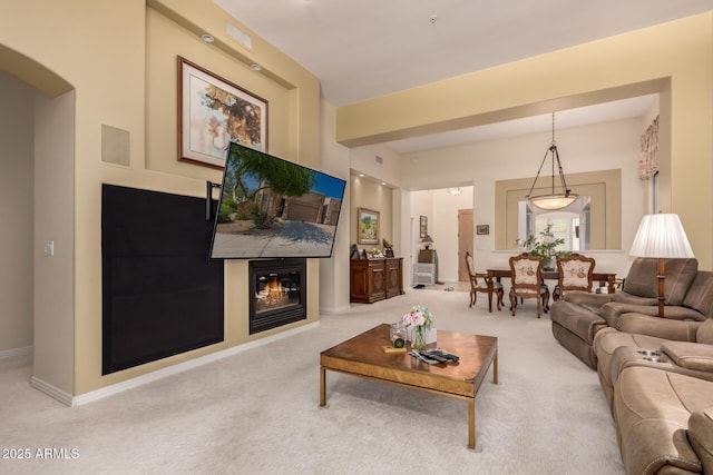 8324 E Cactus Wren Rd, Scottsdale, AZ 85250 - living area with carpet, arched walkways, and a glass covered fireplace