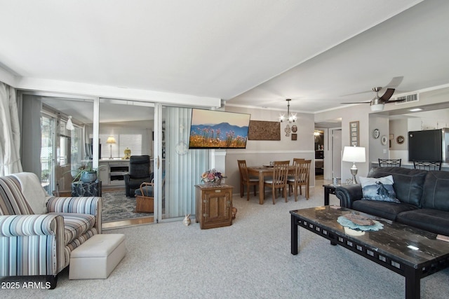 carpeted living area featuring ceiling fan with notable chandelier and visible vents