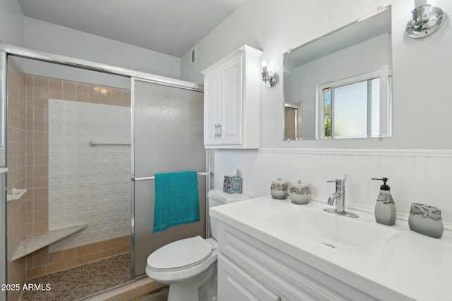 full bath with a stall shower, vanity, and toilet