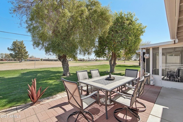 view of patio / terrace with a sunroom and outdoor dining area